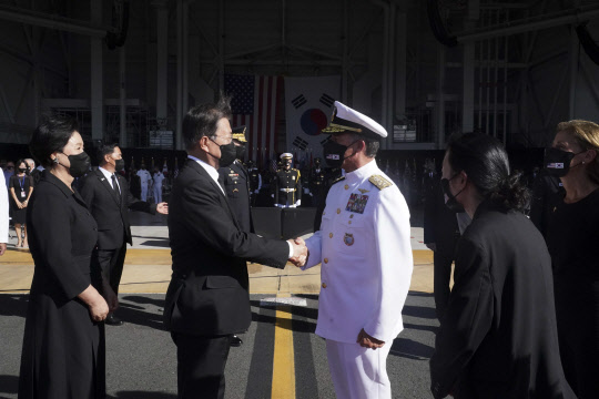 22일(현지시각) 문재인(왼쪽) 대통령이  미국 히캄 공군기지 19번 격납고에서 열린 한미 유해 상호 인수식을 마친 뒤 공군 1호기로 이동하면서 존 아퀼리노(오른쪽) 인도태평양사령관과 악수하고 있다. 연합뉴스.